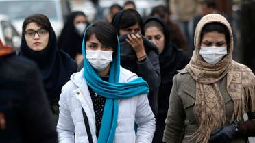 Iranian women wear masks for protection against air pollution as they make their way on a street in northern Tehran. (AP)