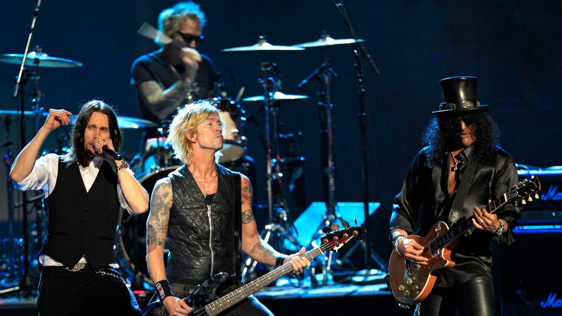 Guns N' Roses' Duff McKagan, center and Slash, right, perform with guest vocalist Myles Kennedy, left, after induction into the Rock and Roll Hall of Fame Saturday, April 14, 2012, in Cleveland. (AP 