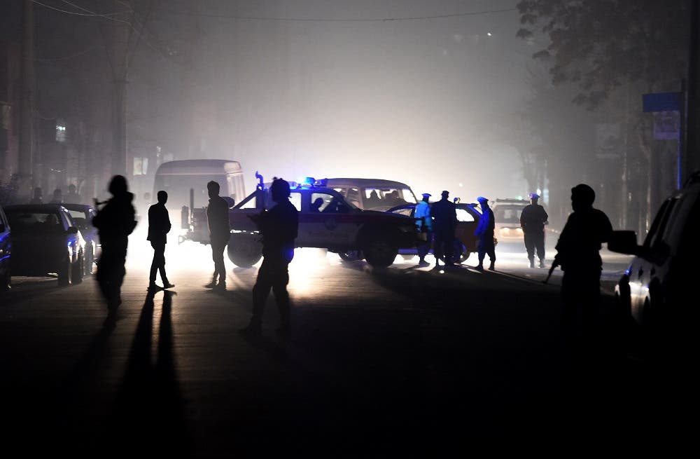 Afghan security officials stand alert as they block the road near the site of a suicide car bomb attack at a French restaurant- Le Jardin in Kabul on January 1, 2016. A Taliban suicide car bomber raided a French restaurant popular with foreigners in Kabul, in a New Year's day attack that marks the latest in a series of brazen insurgent assaults.There was no immediate confirmation of casualties from the attack on Le Jardin, an Afghan-owned eatery, which caused a piercingly loud explosion and left a building engulfed in flames. AFP PHOTO/Wakil Kohsar