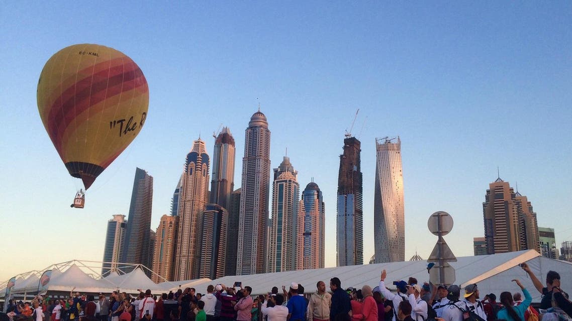 Spectators watch hot air balloons participating in the World Air Games as one soars past the Dubai Marina in Dubai, United Arab Emirates. (AP)