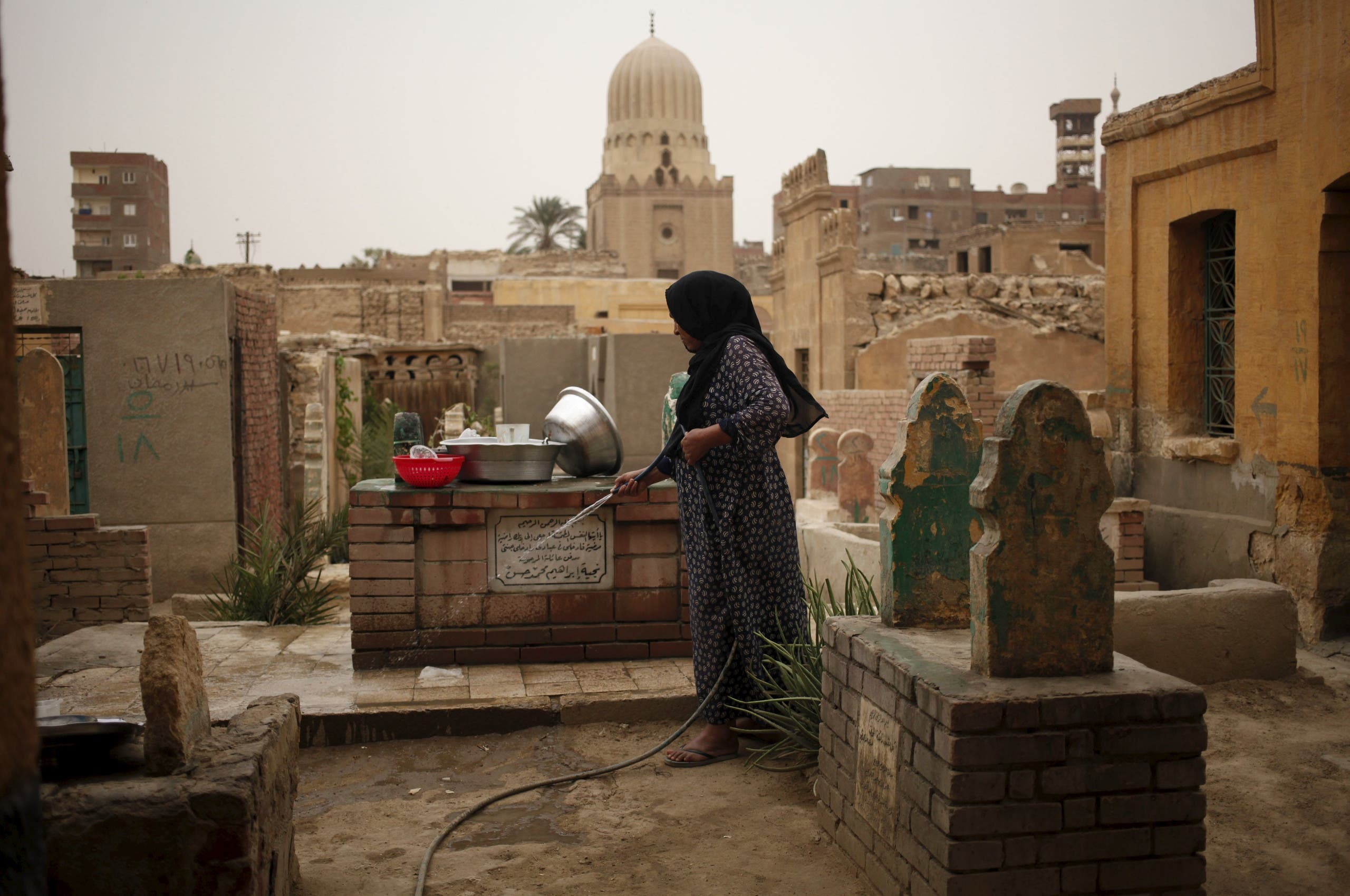 A woman who lives in the Cairo Necropolis cleans a tomb, outside her home in Cairo, Egypt, October 23, 2015.