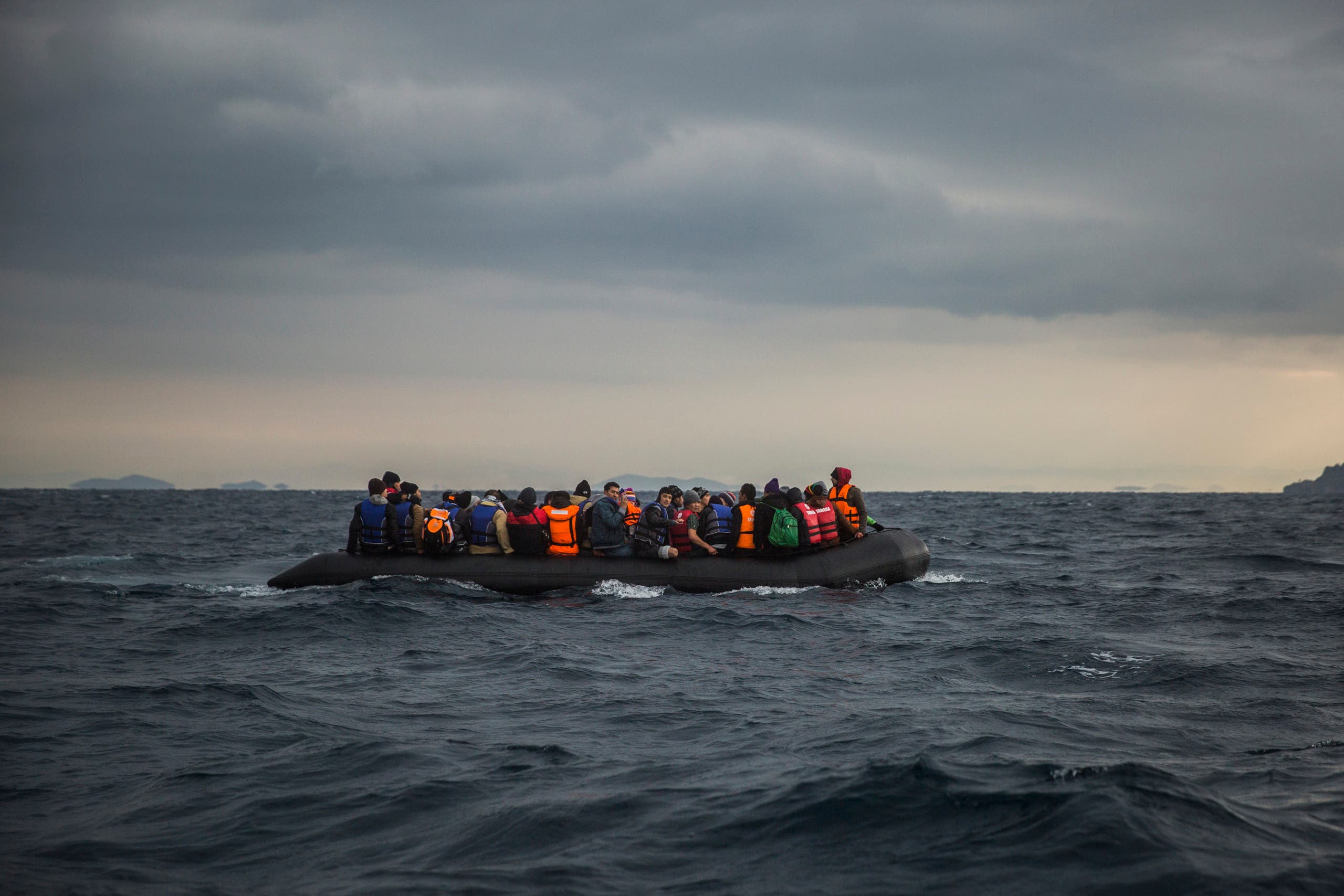 A file photo shows refugees and migrants onboard a dinghy approach the Greek island of Lesbos, after crossing the Aegean sea from Turkey. (AP/Santi Palacios)