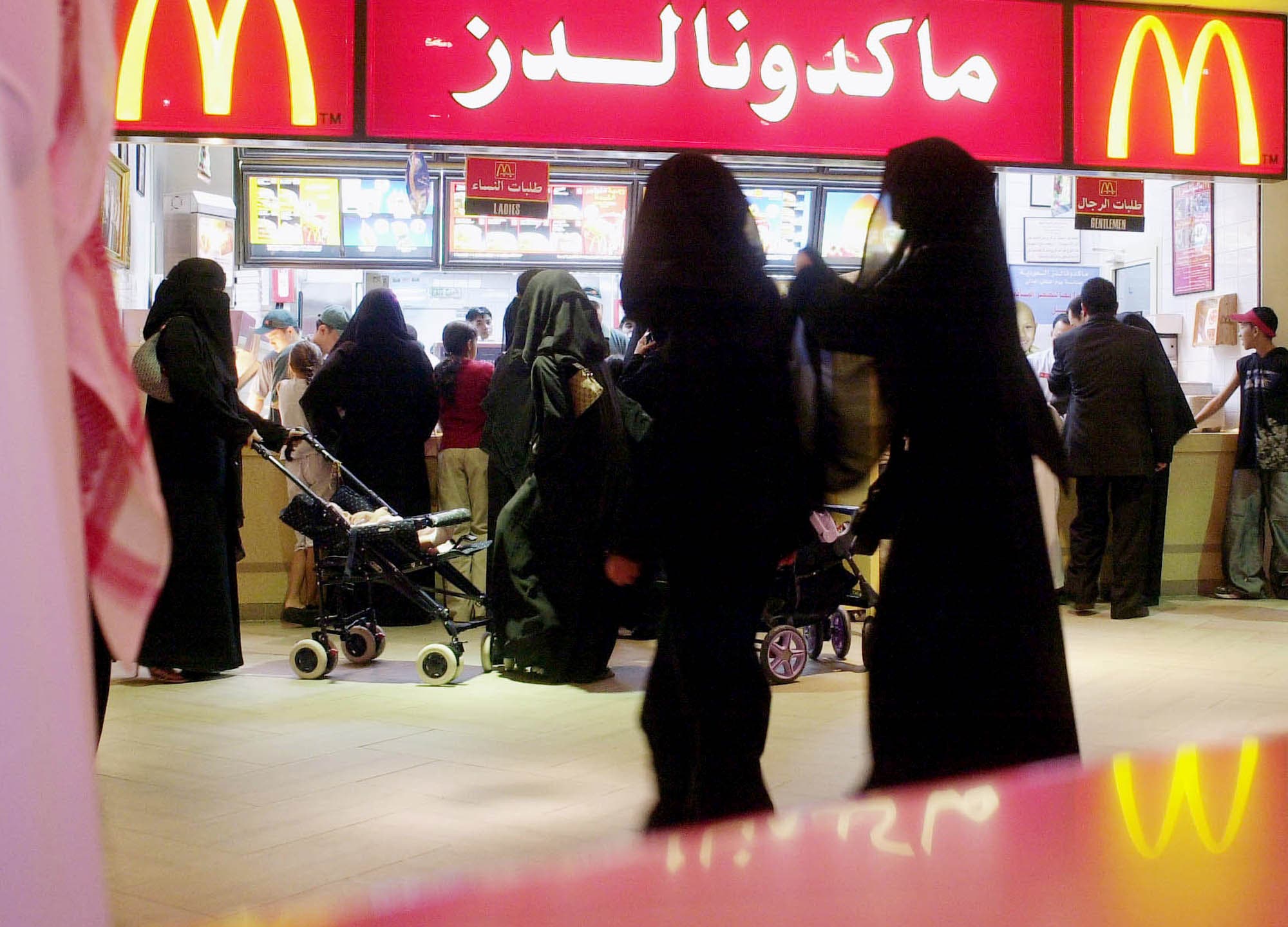 Saudis gather by a McDonalds fast food restaurant in a Riyadh, Saudi Arabia