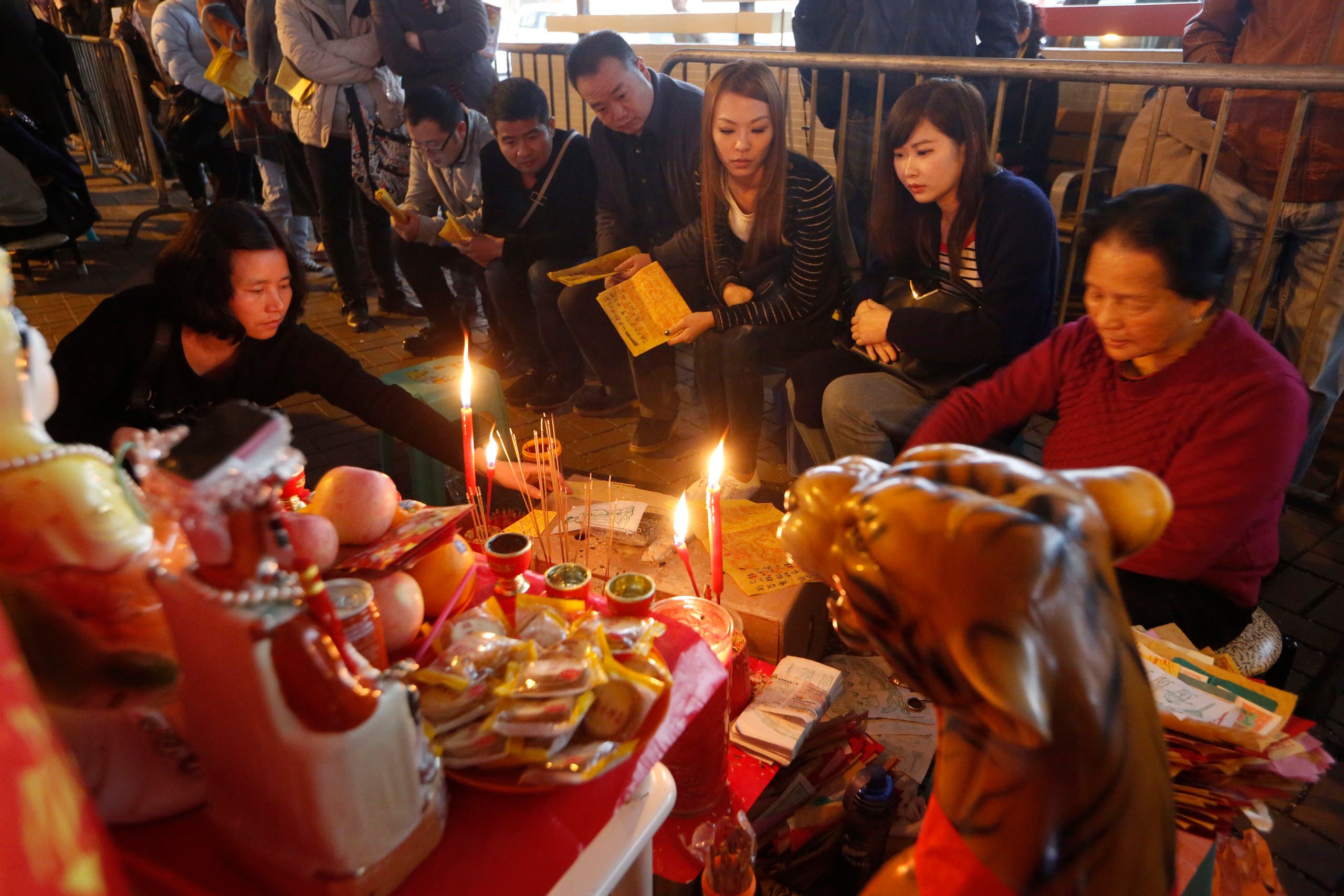 Believers wait at a stall for villain hitting in Hong Kong, Thursday, March 6, 2014. AP