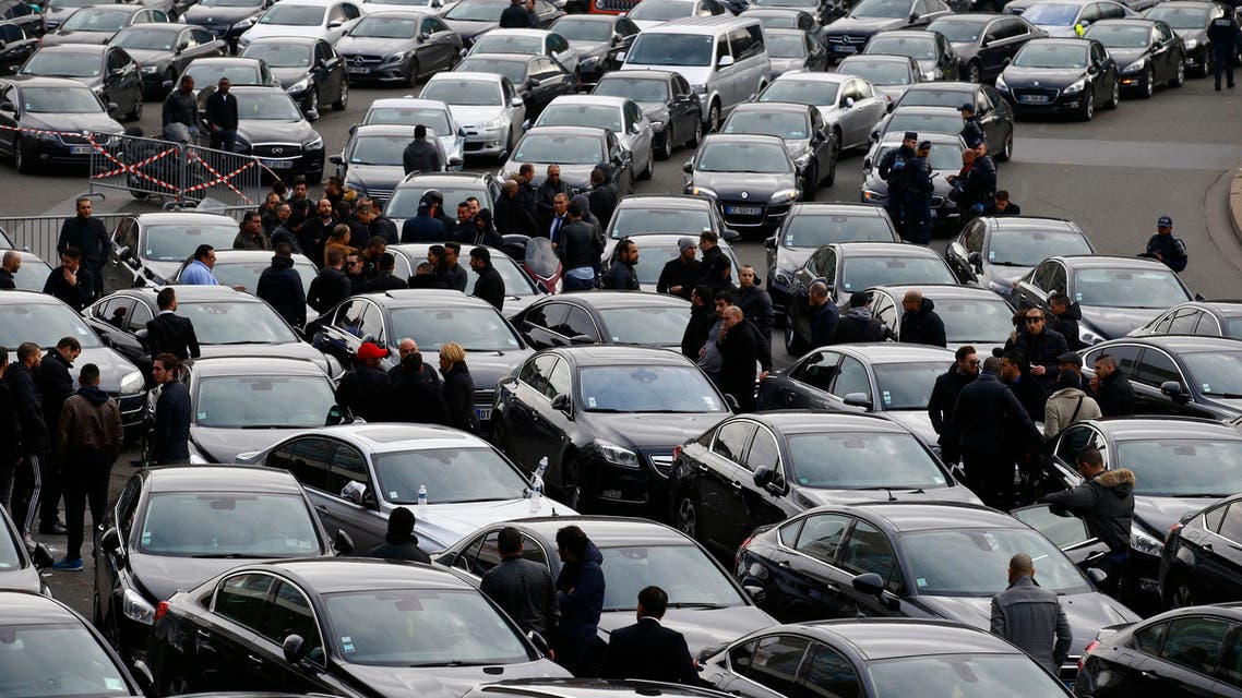 French livery drivers block with their cars a traffic circle at Port Maillot, one of the entries to the city near the Orly airport into Paris, France, Friday, Dec. 18, 2015. (AP)