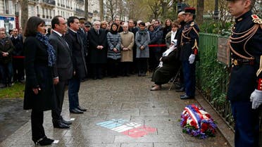 French President Francois Hollande (2ndL), Paris Mayor Anne Hidalgo (L) and Prime Minister Manuel Valls look at a commemorative plaque during a ceremony at the site where a policeman was killed during the last year's January attack in Paris, France, January 5, 2016. (Reuters)