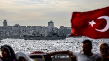   A Turkish flag flies on a ferry as Russian warship, the BSF Saratov 150, is seen sailing through the Bosphorus off Istanbul en route to the eastern Mediterranean sea (AFP Photo/OZAN KOSE)