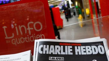 A special edition of the satirical newspaper Charlie Hebdo that marks one year after, "1 an apres" the attacks on it, on a newsstand Wednesday, Jan. 6, 2016 at a train station in Paris. Seventeen people died in the attacks on Charlie Hebdo on Jan. 7, 2015, and a kosher supermarket two days later. All three attackers died. (AP Photo/Francois Mori)