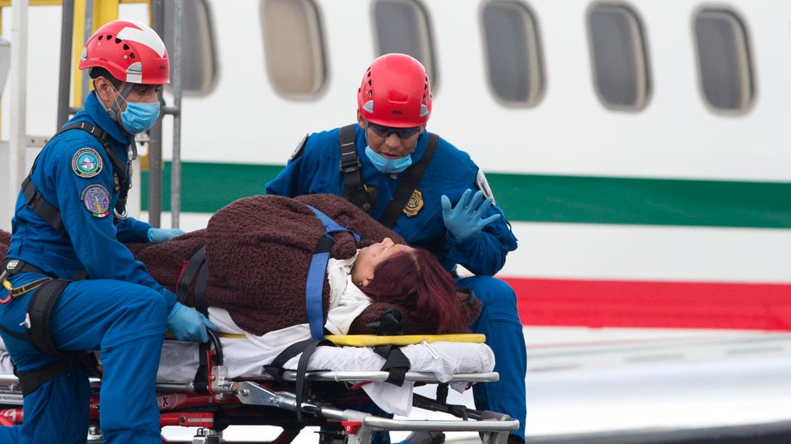 A paramedic talks to an injured woman as she is lowered from a plane carrying six Mexicans who were wounded in an attack by the Egyptian army, in Mexico City, Friday, Sept. 18, 2015. (AP)