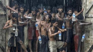 Migrants, who were found at sea on a boat, collect rainwater during a heavy rain fall at a temporary refugee camp near Kanyin Chaung jetty, outside Maungdaw township, northern Rakhine state, Myanmar June 4, 2015. (Reuters)
