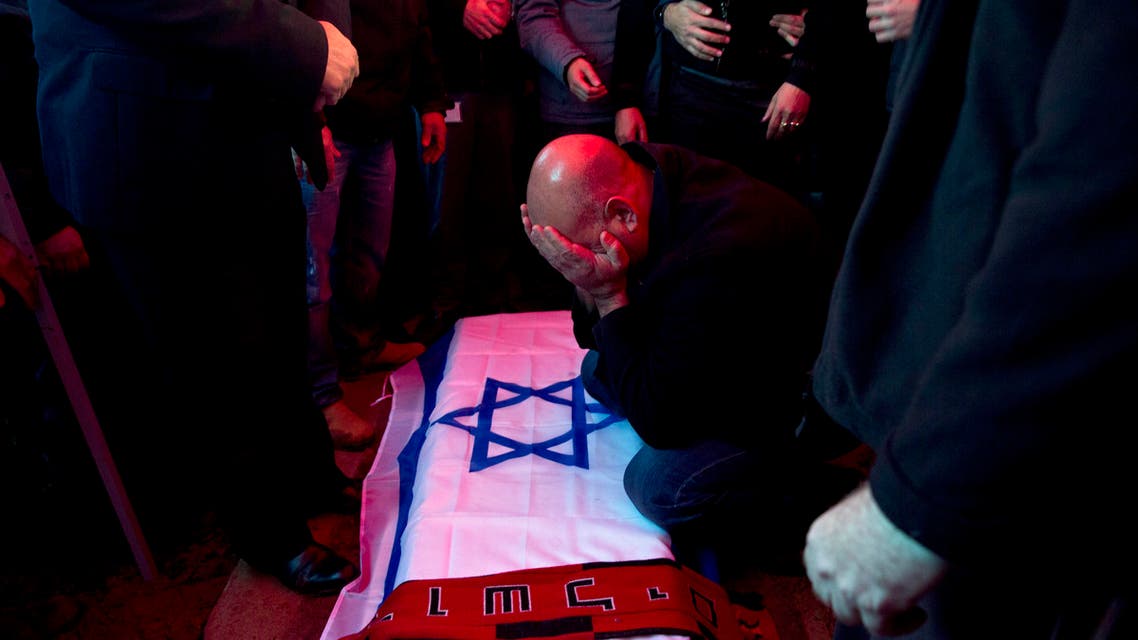 David Bakal, father of Alon Bakal, who was killed when a gunman opened fire at a bar in Tel Aviv on Friday, mourns over his body during his funeral in Carmiel, northern Israel, Sunday, Jan. 3, 2016. Israeli police are on "heightened alert" as they continue the manhunt for a gunman who killed two people and wounded several others Friday when he opened fire at a bar in Tel Aviv. (AP Photo/Ariel Schalit)