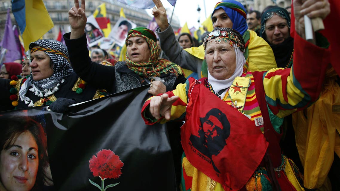 579 - Paris : TOPSHOT - Kurdish women shout slogans while demonstrating in Paris on January 9, 2016, to commemorate the killing of the three top Kurdish activists Sakine Cansiz, Fidan Dogan and Leyla Soylemez and to ask for "justice". The three women were shot to death on January 9, 2013 at the Kurdish Information Centre in Paris. The motive of the triple killing remains unclear even-though investigators suspected an implication of Turkey's secret services. / AFP / THOMAS SAMSON