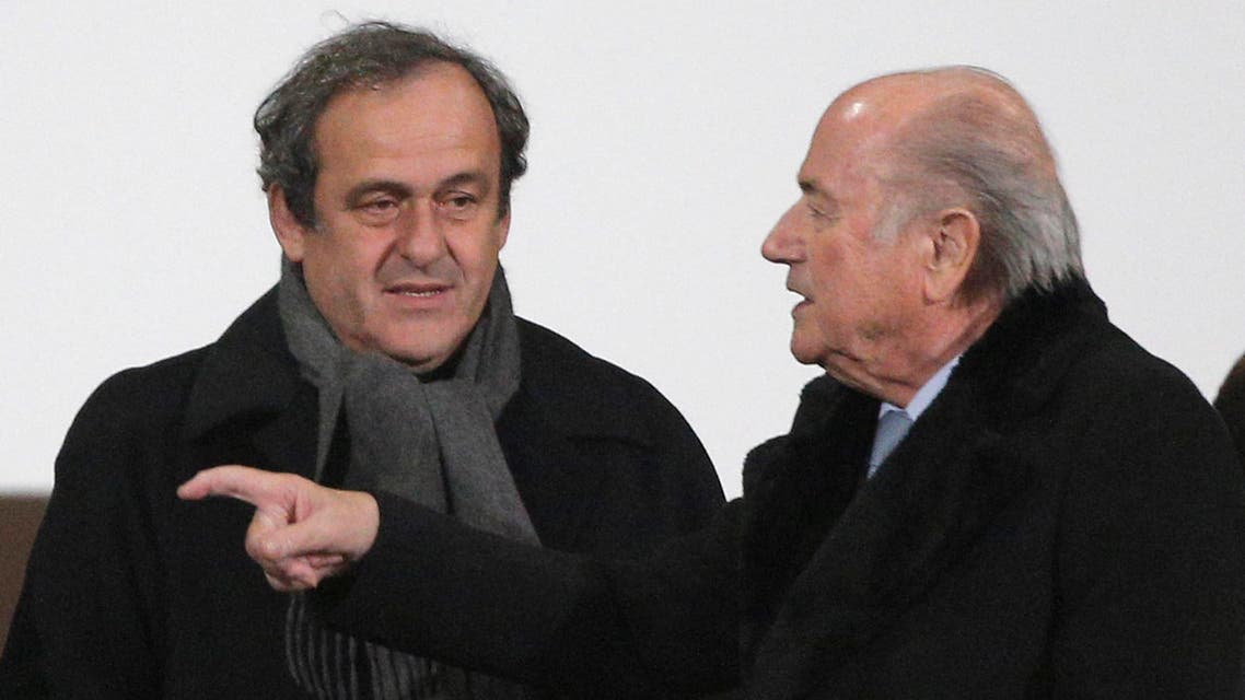 In this Dec. 16, 2014 file photo FIFA president Sepp Blatter, right, and UEFA president Michel Platini talk before the semi final soccer match between Real Madrid and Cruz Azul at the Club World Cup soccer tournament in Marrakech, Morocco. AP
