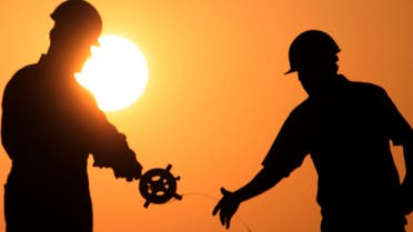 Oil men work on a new oil rig at sunset Thursday, April 1, 2010, in the Persian Gulf desert oil field of Sakhir, Bahrain.  (AP)