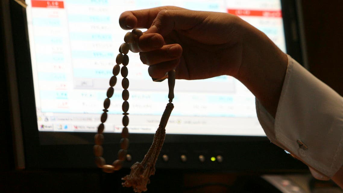 A Saudi trader holds prayer beads as he works at the Saudi Investment Bank in Riyadh (File photo Reuters)