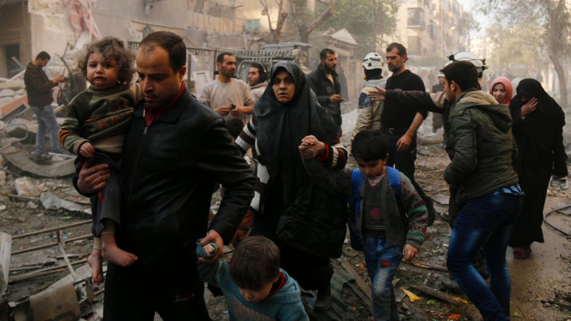 Syrians make their way through debris as they leave for a safer place following air strikes in the rebel-controlled side of the northern city of Aleppo on January 13, 2016. (AFP)