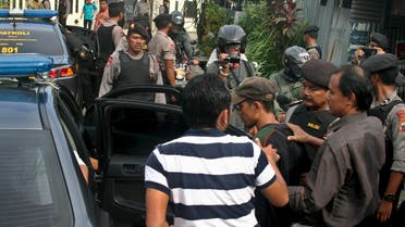 Police officers escorts a man (C, with a cap) who was arrested during a raid in the Langgen village in Tegal, Indonesia Central Java, January 15, 2016 in this photo taken by Antara Foto. Indonesia's police chief said on Saturday security forces have arrested 12 people linked to this week's attack by Islamic State militants in the centre of Jakarta. REUTERS/Oky Lukmansyah/Antara Foto ATTENTION EDITORS - THIS IMAGE HAS BEEN SUPPLIED BY A THIRD PARTY. IT IS DISTRIBUTED, EXACTLY AS RECEIVED BY REUTERS, AS A SERVICE TO CLIENTS. FOR EDITORIAL USE ONLY. NOT FOR SALE FOR MARKETING OR ADVERTISING CAMPAIGNS. MANDATORY CREDIT. INDONESIA OUT. NO COMMERCIAL OR EDITORIAL SALES IN INDONESIA.