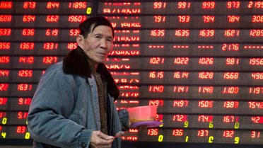 An investor walks past an electronic screen showing stock information at a brokerage house in Nanjing. (Reuters)