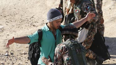 A Jordanian soldier searches a Syrian refugee crossing into Jordanian territory, near the town of Ruwaished, at the Hadalat area, east of the capital Amman. (Reuters)