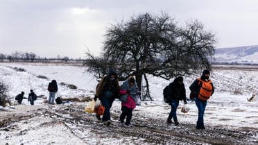 Migrants walk through the snow after crossing the Macedonian border into Serbia near the village of Miratovac on January 18, 2016 (AFP)