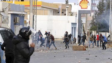 Protesters throw items to police forces in the city of Ennour, near Kasserine, Tunisia, Wednesday, Jan. 20, 2016. Tunisia has declared a curfew in the western city after clashes between police and more than 1,000 young protesters demonstrating for jobs. Tensions have risen in Kasserine since Sunday when an unemployed youth killed himself by scaling an electricity transmission tower to protest his rejection for a government job. (AP Photo/Moncef Tajouri)