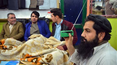 In this photo taken on Sunday, Jan. 10, 2016, an Afghan shopkeeper, right, listens to Islamic State Radio at his shop in Jalalabad, capital of Nangarhar province, Afghanistan. AP