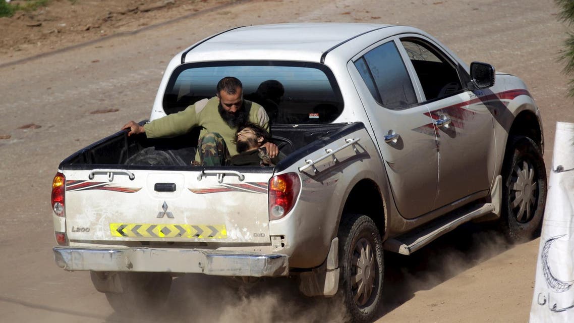 An injured Ahrar al-Sham Islamic Movement rebel fighter rides on the back of a pick-up truck with a fellow fighter in the northwestern city of Idlib March 26, 2015. (Reuters)