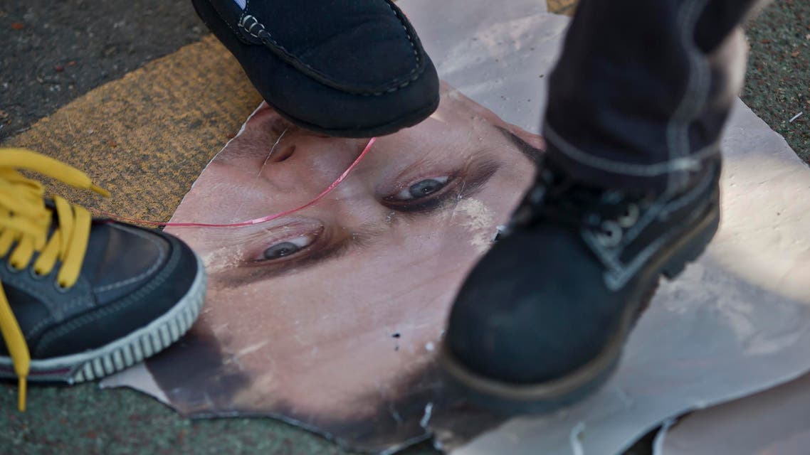 Children step on a poster depicting Syrian President Bashar Assad during a protest by members of the Syrian community in Bucharest, Romania, Saturday, Oct. 19, 2013.  (AP)