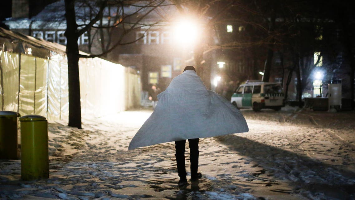 A man covered with blanket against the cold arrives at the central registration center for refugees and asylum seekers, LaGeSo (Landesamt fuer Gesundheit und Soziales - State Office for Health and Social Affairs) in Berlin, Wednesday, Jan. 6, 2016. German Interior Minister will present a migration report on Wednesday. (AP Photo/Markus Schreiber)