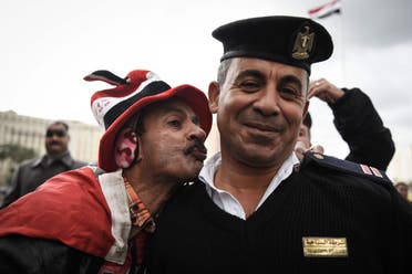 A pro-government Egyptian man kisses a policeman on Cairo's landmark Tahrir Square on January 25, 2016, as the country marks the fifth anniversary of the 2011 uprising. AFP