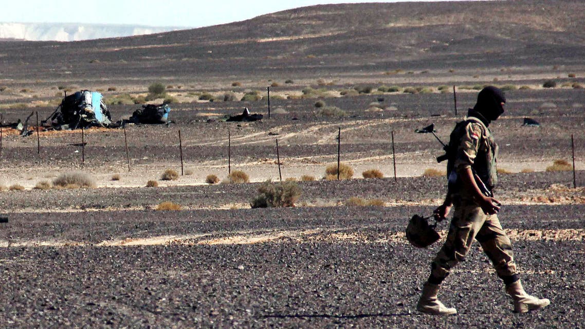 FILE - In this Sunday, Nov. 1, 2015 file photo, A member from the Egyptian security forces walks by debris of a Russian airplane at the site a day after the passenger jet bound for St. Petersburg, Russia, crashed in Hassana, Egypt. Egypt's chief investigator says a preliminary investigation into the October crash of a Russian passenger plane in Sinai has found no indication yet of any "illegal or terrorist act." (AP Photo, File)