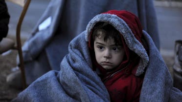 A migrant boy is covered with a blanket as he and other refugees and migrants wait to cross the Greek-Macedonian border near the village of Idomeni, Greece, January 28, 2016. REUTERS/Alexandros Avramidis GREECE OUT. NO COMMERCIAL OR EDITORIAL SALES IN GREECE