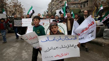 Residents carry banners and opposition flags as they march during a protest in Aleppo, asking for the release of prisoners held in government jails and lifting of the siege on besieged areas. (Reuters)