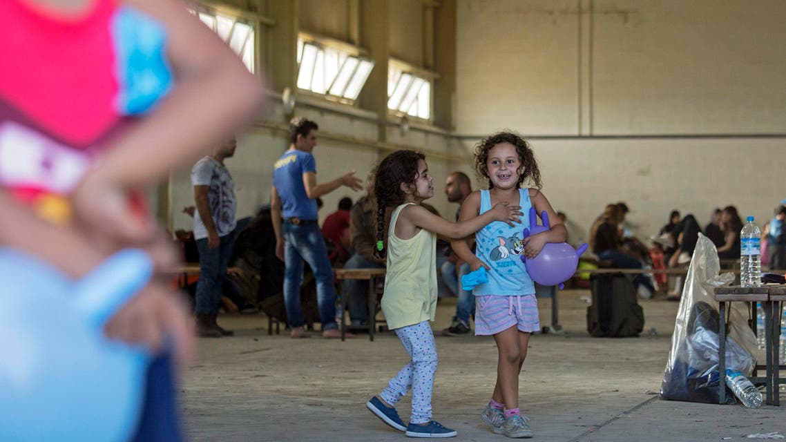 Syrian migrants are temporarily housed at a warehouse after coming ashore at RAF base Akrotiri, Cyprus, Wednesday, Oct. 21, 2015. AP