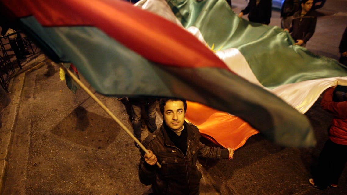 A protester waves a Kurdish flag during a protest outside the offices of European Parliament in Athens on Saturday, Jan. 18 2013. Several hundred Kurds marched through central Athens Saturday to demand an independent state. The march was one of several staged worldwide by the Kurdish Supreme Council to ask that the Kurdish question be on the agenda of the upcoming Geneva II Middle East Peace Conference on the Syrian conflict. An estimated 26-33 million Kurds inhabit a region known as Kurdistan, which includes adjacent parts of Turkey, Iran, Iraq and Syria. (AP Photo/Kostas Tsironis)