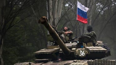 A pro-Russian rebel looks up while riding on a tank flying Russia's flag, on a road east of Donetsk, eastern Ukraine. (File photo: AP)