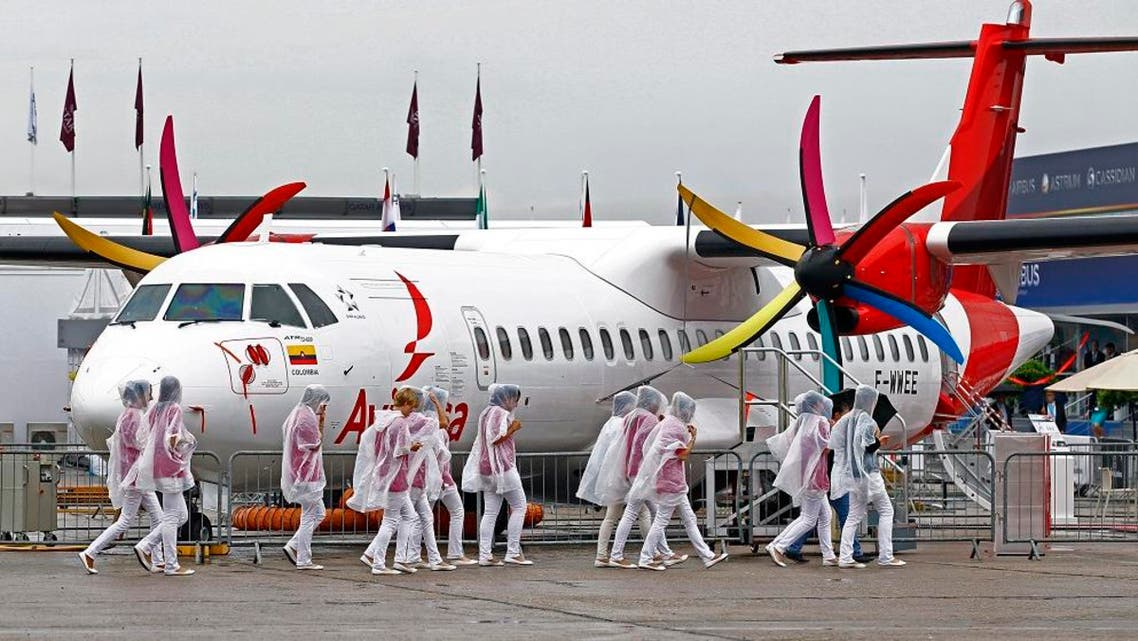A group of hostesses walk past an Avianca ATR 72-600, displayed at the 50th Paris Air Show at Le Bourget airport, north of Paris, Thursday June 20, 2013. (AP Photo/Remy de la Mauviniere)