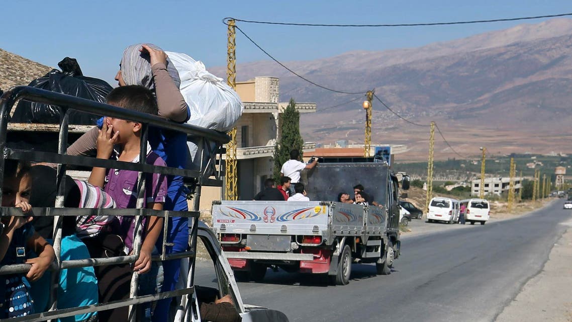 Lebanese citizens in the back of a pickup truck flee Arsal, a predominantly Sunni Muslim town near the Syrian border in eastern Lebanon, Monday, Aug. 4, 2014. Thousands of Lebanese civilians and Syrian refugees packed cars and pickup trucks Monday, fleeing an eastern border town that was overrun by militants from neighboring Syria as Lebanese troops fight to liberate the area. (AP Photo/Bilal Hussein)