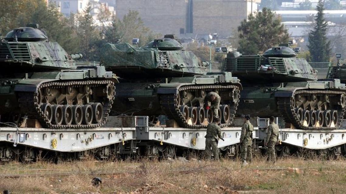 Turkish soldiers check tanks stationed at the train station after their arrival from western Turkey, in Gaziantep, Turkey, Friday, Nov. 27, 2015. Turkey shot down the Russian Su-24 bomber at the Syrian border on Tuesday, insisting it had violated its airspace despite repeated warnings. The tanks are expected to be deployed to the border with Syria.(DHA agency via AP) 