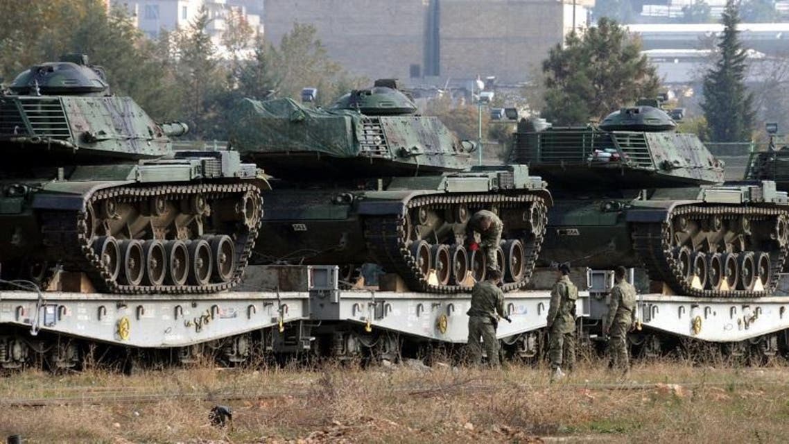Turkish soldiers check tanks stationed at the train station after their arrival from western Turkey, in Gaziantep, Turkey, Friday, Nov. 27, 2015. Turkey shot down the Russian Su-24 bomber at the Syrian border on Tuesday, insisting it had violated its airspace despite repeated warnings. The tanks are expected to be deployed to the border with Syria.(DHA agency via AP)