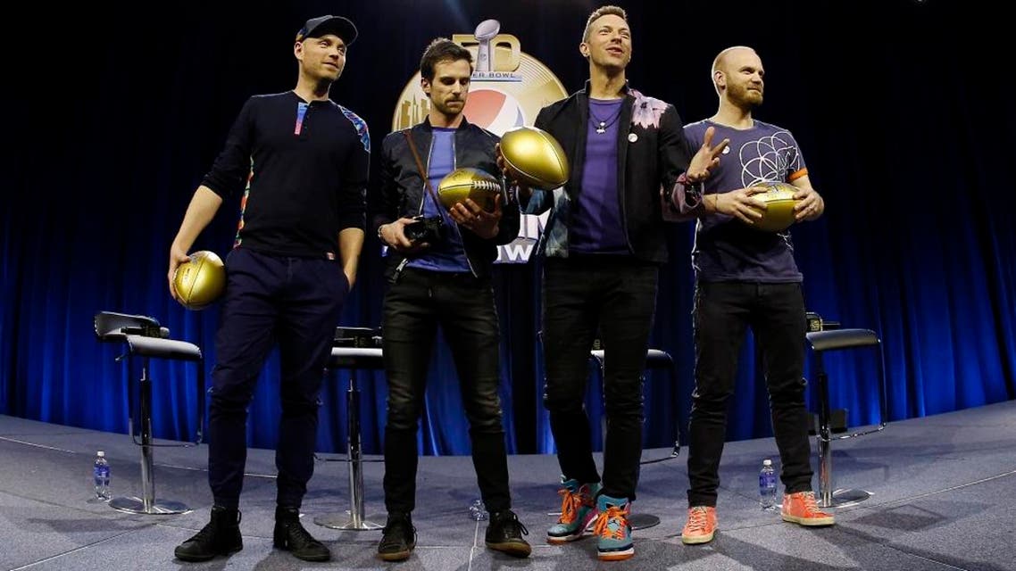Jonny Buckland, left to right, Guy Berryman, Chris Martin and Will Champion of Coldplay hold footballs during a halftime news conference for the upcoming NFL Super Bowl 50 football game Thursday, Feb. 4, 2016, in San Francisco. (AP Photo/Matt Slocum)