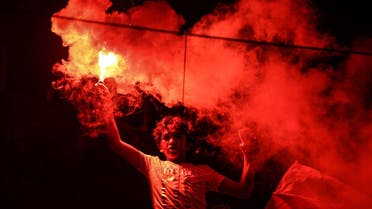In this July 26, 2015 photo, a member of Zamalek's football club's Ultras White Knights group (UWK), the club's hardcore fan base, lights flares during a friend's bachelor party in Cairo. (AP)