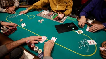 In this Wednesday, Feb. 3, 2016 photo a card dealer deals a game of poker to patrons at Twin River Casino, in Lincoln, R.I. Casinos far from Las Vegas are experimenting with different ways to draw millennials. (AP)