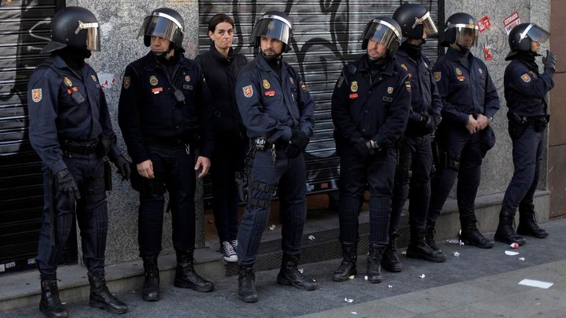 Police riots stand guard in front of a restaurant as the owner waits for the protestors to go away during a general strike in Madrid, Spain, Wednesday, Nov. 14, 2012. Spain's main trade unions stage a general strike, coinciding with similar work stoppages in Portugal and Greece, to protest government-imposed austerity measures and labor reforms. The strike is the second in Spain this year. (AP Photo/Andres Kudacki) Use Information This content is intended for editor