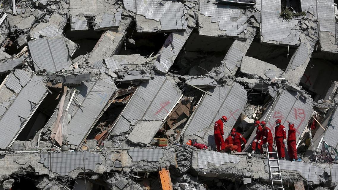 Rescue personnel work at the site where a 17-storey apartment building collapsed after an earthquake hit Tainan, southern Taiwan February 7, 2016. REUTERS