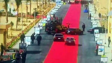 In this Saturday, Feb. 6, 2016 image taken from Egypt State TV, Egyptian President Abdel-Fattah el-Sissi's motorcade drives on a red carpet during a trip to open social housing projects in a suburb of Cairo, Egypt. AP