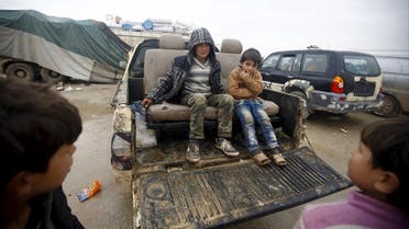 Internally displaced Syrian boys sit in the back of a truck in front of a refugee camp near the Bab al-Salam crossing. (Reuters)