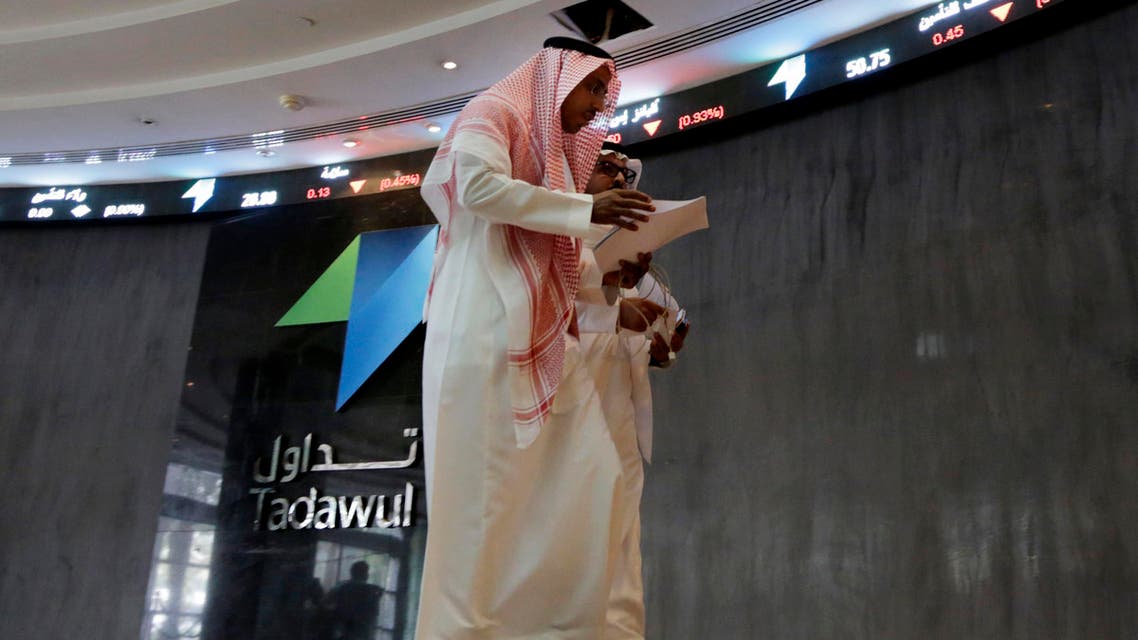 Saudi men walk at the Tadawul Saudi Stock Exchange, in Riyadh, Saudi Arabia, Monday, June 15, 2015. (AP)