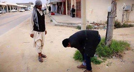 صورة تناقلتها مواقع ليبية لعنصر من داعش يجبر شابا من سرت على رفع سرواله
