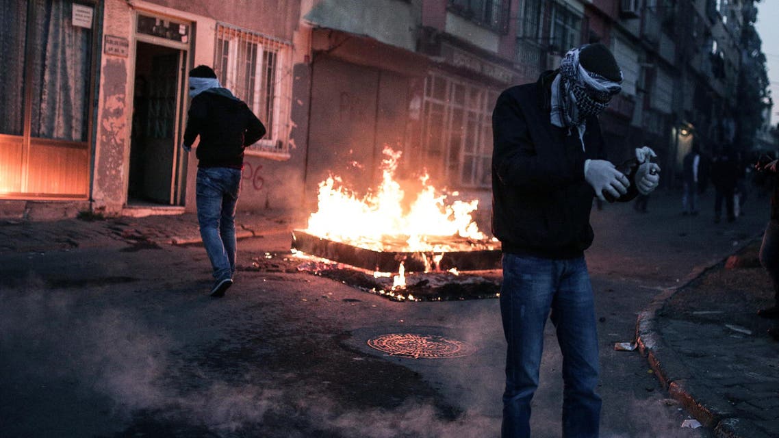 A masked man prepares to throw a petrol bomb toward police who used water cannon and teargas to disperse people protesting against security operations against Kurdish rebels in southeastern Turkey, in Istanbul, Sunday, Dec. 20, 2015. AP